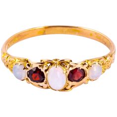 Either side of the glittering garnets in this ring are gorgeous and colourful opals. The garnets total 30pts and the opals total approx 45pts. The setting and shoulders of this ring are so decorative and modelled in 9carat gold. Ring Size: T or 9 1/2 Band Width: 7mm Height Off Finger: 4mm Weight: 1.9g Victorian Multi-stone Opal Ring As Gift, Victorian Multi-stone Opal Ring For Gift, Victorian Multi-stone Opal Ring, Edwardian Rings, Edwardian Ring, Garnet Ring, Unique Engagement, Contemporary Jewelry, Unique Engagement Rings