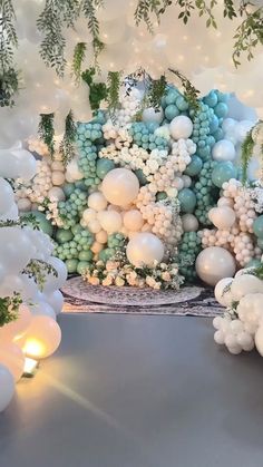 an arrangement of balloons and greenery on display