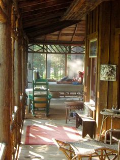 the inside of a wooden cabin with chairs and tables on either side of the room