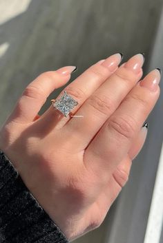 a woman's hand with a diamond ring on it