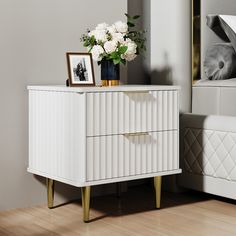 a white dresser with flowers and pictures on it