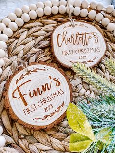 two personalized wooden christmas ornaments sitting on top of a basket