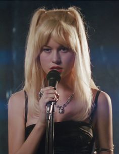 a woman with blonde hair holding a microphone