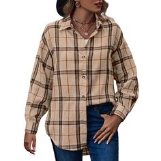 a woman wearing a plaid shirt and hat with her hands in her pockets while standing