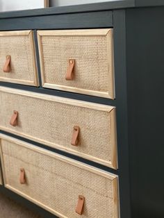 an old dresser has been painted with dark blue paint and jute baskets on the drawers