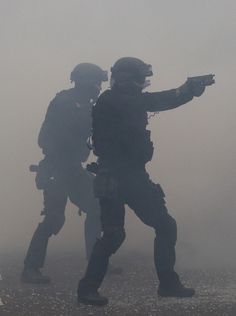 two soldiers in the fog pointing at something