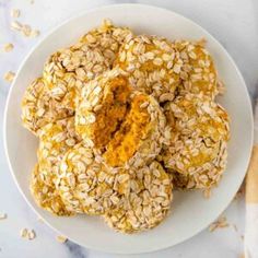 a white plate topped with oatmeal cookies on top of a marble counter