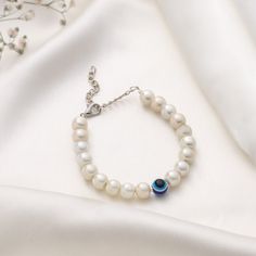 Crafted with meticulous attention to detail, the bracelet features lustrous white beads that delicately encircle the wrist, creating a timeless and versatile piece that complements any outfit. The centerpiece of this enchanting bracelet is the captivating Evil Eye charm, adorned with intricate beading and a mesmerizing white and blue eye. White Pearl Jewelry Gift For Her, Elegant Evil Eye Bracelet With Round Beads, White Hypoallergenic Pearl Bracelet, Pearl White Beaded Bracelets As Gift, Gift Pearl Bracelet With Round Shape, Pearl White Bracelet With Round Beads For Gifts, White Rosary Bracelet With Round Beads For Friendship, Elegant White Beaded Bracelet As Gift, Beaded Bracelets With Pearl Charm For Gift