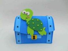 a blue and green box with a turtle on it's back, sitting on top of a white surface