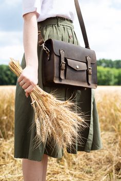 "This leather satchel manifests efficient storage, carrying comfort, and vintage elegance. Just right in size, this versatile leather briefcase holds as much as you need without looking bulky. Small internal and external pockets offer an apt spot for keeping essentials secured and organized. A detachable, adjustable shoulder strap and optional top handle allow you to wear it whichever suits your active lifestyle. Safe, neat belt buckles and patinaed leather bring a final touch of fine vintage.sa Brown Satchel, Leather Satchel Handbags, Model Features, Espresso Brown, Dark Brown Color, Leather Messenger Bag, Leather Briefcase, Satchel Purse, Leather Messenger