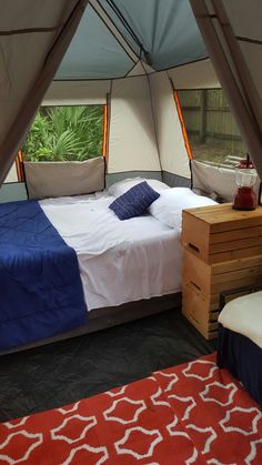 a bed in a tent with blue and white sheets