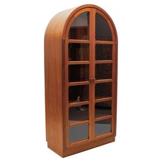 an arched wooden cabinet with glass doors