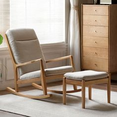 a rocking chair and foot stool in front of a window