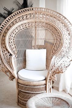 a wicker chair with a white cushion and pillow