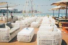 many white wicker chairs and tables with umbrellas