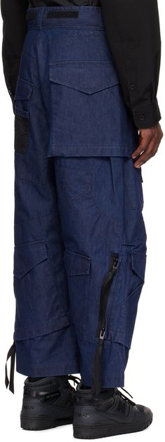 Non-stretch chambray jeans. Flap pockets throughout. · Paneled construction · Belt loops · Velcro detailing at waistband · Zip-fly · Mesh pocket at front and back leg · Tucks at knees · Two-way zip detailing at outseams · Bonded nylon taffeta lining Part of the Junya Watanabe MAN collection. Supplier color: Indigo Baggy Indigo Bottoms With Pockets, Dark Wash Utility Pants With Pockets, Utility Dark Wash Pants With Pockets, Baggy Indigo Jeans With Pockets, Utility Pants With Pockets In Dark Wash, Urban Dark Wash Pants With Pockets, Urban Style Dark Wash Bottoms With Cargo Pockets, Urban Dark Wash Bottoms With Cargo Pockets, Denim Cargo Pants With Dark Wash