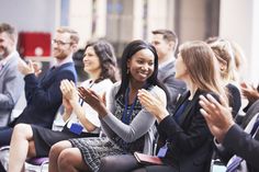 a group of people applauding each other with their hands in the air