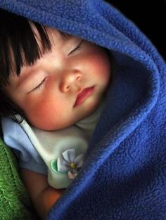 a baby sleeping under a blue blanket with the words goeti nag above it