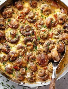 a skillet filled with meat and cheese covered in melted cheese, mushrooms and parsley