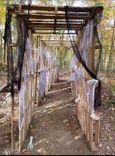 some kind of wooden structure in the woods with ghost decorations on it's sides