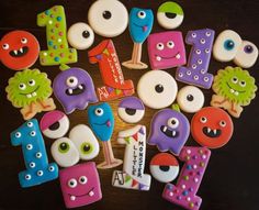 decorated cookies are arranged in the shape of numbers and monsters for birthdays or baby showers