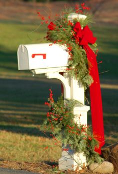 a mailbox decorated with greenery and red ribbon