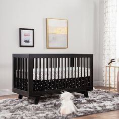 a baby's room with a black crib and white rug on the floor