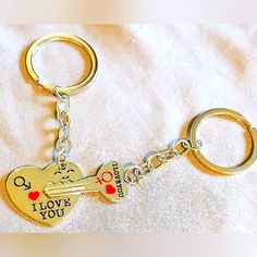 two heart shaped key chains with i love you written on them