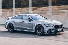 a silver mercedes cla driving on a race track