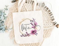 a tote bag sitting on top of a table next to some flowers and greenery