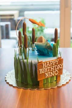 a birthday cake with an image of a fish in the pond on top of it