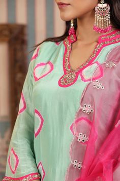 A timeless wardrobe essential, this mint green suit set is crafted from muslin fabric and features handwork that is sure to captivate. Accompanied with an organza dupatta, this set exudes elegance and sophistication. Relaxed enough for every day and luxurious enough for special occasions, this is an exclusive piece that will never go out of style. No. of pieces - 3 piece set. Color - Green and Pink. Fabric - Muslin. Washing Instructions - Dry Clean. Elegant Pista Green Straight Kurta Set, Green Anarkali Set For Diwali Celebration, Diwali Celebration Green Anarkali Set, Green Cotton Silk Palazzo Set With Dabka Work, Green Tissue Silk Kurta For Diwali, Unstitched Green Tissue Silk Suit With Resham Embroidery, Pista Green Cotton Silk Sets For Festivals, Green Anarkali Kurta For Celebration, Pista Green Palazzo Set With Mirror Work