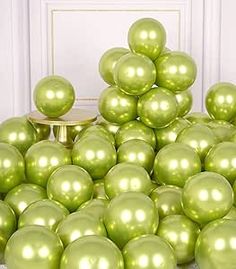 a pile of shiny green balls sitting on top of each other in front of a white door