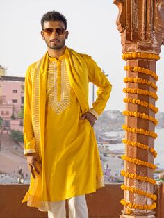 SHRESTHA BY VASTRAMAY Men's Yellow Silk Machine Embroidered Kurta Luxuriate in this vibrant yellow kurta, featuring intricate machine embroidery. Made from a silk blend, this kurta boasts a comfortable and stylish fit. Pair it with a dhoti or pajamas for a complete traditional look. Key Features Yellow silk blend with machine embroidery Mandarin collar Long sleeves Side slits Pockets Specifications Sleeve Length: Full Sleeves Top Shape: Straight Top Hemline: Straight Top Length: Knee Length Mate Semi-stitched Yellow Kurta For Transitional Season, Yellow Sherwani With Resham Embroidery In Chanderi, Chanderi Kurta With Gold Embroidery Long Sleeve, Chanderi Long Sleeve Kurta With Gold Embroidery, Yellow Chanderi Sherwani Straight Kurta, Yellow Chanderi Sherwani With Resham Embroidery, Traditional Yellow Chanderi Sherwani, Yellow Chanderi Sherwani With Traditional Drape, Yellow Chanderi Sherwani With Chikankari Embroidery