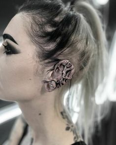 a woman with tattoos on her face and ear