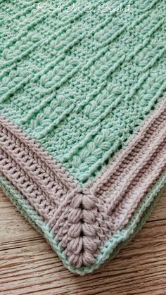 a crocheted blanket on top of a wooden floor