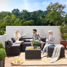 three people sitting on couches in the middle of a patio