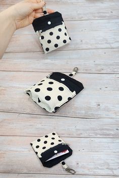 two small purses with black and white polka dots on them are being held by a hand