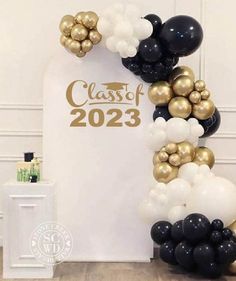 the balloon arch is decorated with black, white and gold balloons that read class of 202