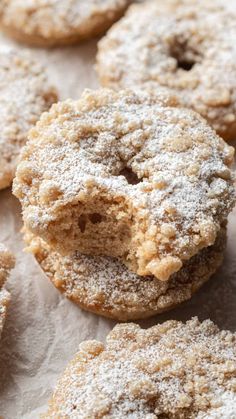 powdered sugar covered doughnuts sitting on top of paper