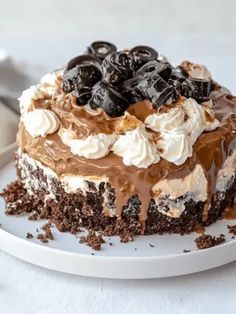 a cake with chocolate, cream and cherries on top is sitting on a plate