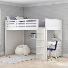 a white loft bed with desk and chair in a room that has wood flooring