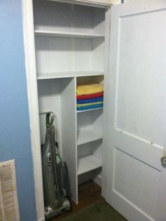 an open closet with a vacuum cleaner in it