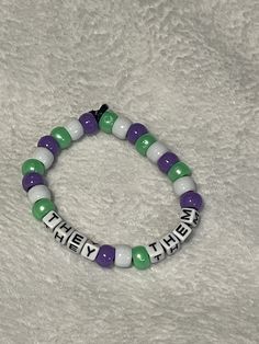 hi there! welcome back to loom mountain! ☮️ this listing is for a kandi or pony bead bracelet on a thick stretch cord, with "they/them" in the middle. the surrounding beads are oearlescebt green, white, and purple, the colors of the genderqueer pride flag. thanks again for stopping by! They Them, Bracelets Kandi, They Them Pronouns, Pony Bead Bracelets, Kandi Bracelets, Beads Bracelet Design, Bracelet Design, Kandy, Purple And Green