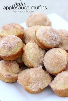 some sugared muffins on a white plate with the words appleauce muffins