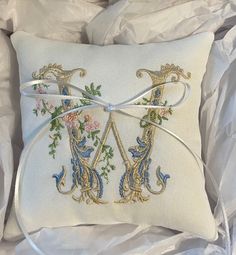 a white pillow with two decorative letters on it