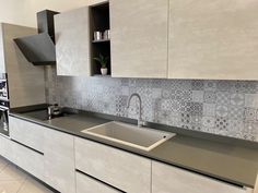 a modern kitchen with white cabinets and grey counter tops, stainless steel faucet