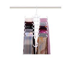 three pairs of socks hanging from a rail on a clothes rack with two ties attached to it