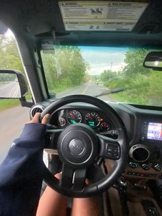 the driver is driving his truck down the road in front of the camera man and looking out the window