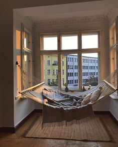 a hammock hanging in front of a window